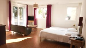a bedroom with a bed and a chair and windows at Zenao Appart's Nevers - Renardats in Nevers
