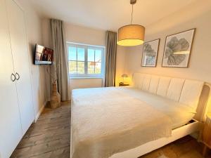 a bedroom with a large bed and a window at Ferienhaus 1 Fuchsweg in Stralsund