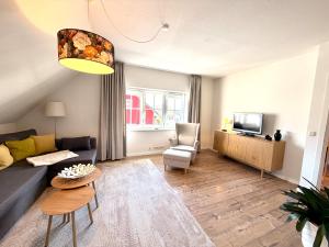 a living room with a couch and a tv at Ferienhaus 1 Fuchsweg in Stralsund