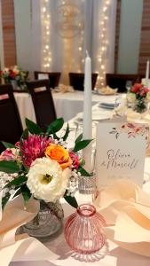 a table with a vase with flowers on it at Brauer Panzió in Mecseknádasd
