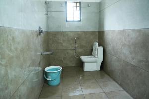 a bathroom with a toilet and a window at Aqua Terra Villas in Belūr