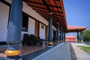a porch of a house with chairs and a roof at Aqua Terra Villas in Belūr