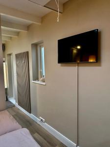 a living room with a flat screen tv on the wall at Studio Oranje Nassau aan Zee in Zandvoort