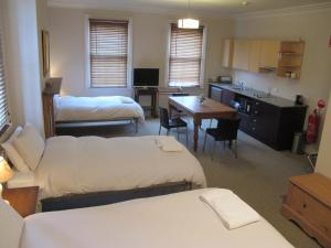 a room with two beds and a kitchen with a table at The Playhouse Hotel in Barraba +1 photo