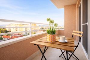 a table with a cup and a plant on a balcony at Urban Serviced Apartments in Skopje