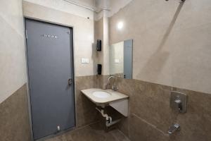 a bathroom with a sink and a mirror at Hotel Blueberry Bhedaghat in Jabalpur +15 photos