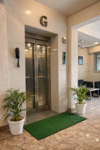 an office with two potted plants in a lobby at Hotel Blueberry Bhedaghat in Jabalpur