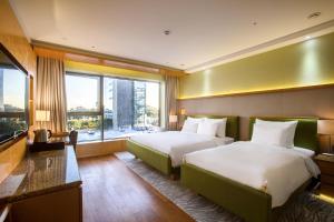 a hotel room with two beds and a large window at Baymond Hotel in Busan