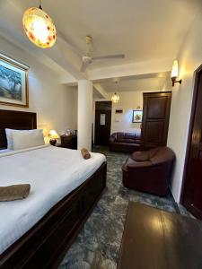 a bedroom with a large bed and a couch at Paragon mirissa by REO in Mirissa +8 photos