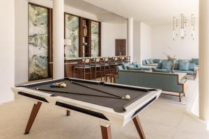 a living room with a pool table and chairs at One&Only Kéa Island in Pisses