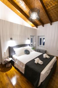 a bedroom with a large bed with two towels on it at Akrolithia Guest House in Valanidorachi