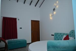 a living room with a blue couch and a bed at French Villa in Dankotuwa