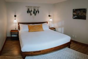 a bedroom with a large white bed with two lamps at Quadra Island Mist in Quathiaski Cove