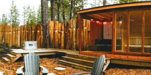 a wooden cabin with a bench and a wooden fence at Quadra Island Mist in Quathiaski Cove