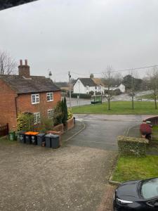 a house with trash cans in front of a street at Pine Tree Cottage in Linslade