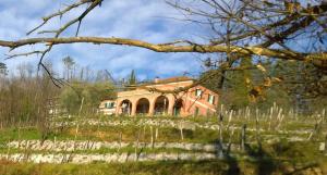 une maison au sommet d'une colline dans un champ dans l'établissement Agriturismo Cerrolungo, à La Spezia