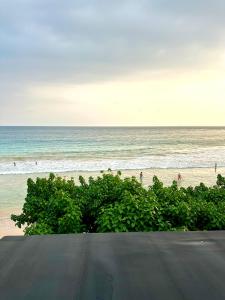 a view of the beach with people in the ocean at Paragon mirissa by REO in Mirissa