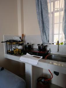 a kitchen counter with pots and pans on a stove at FloJoy Haven Machakos in Machakos