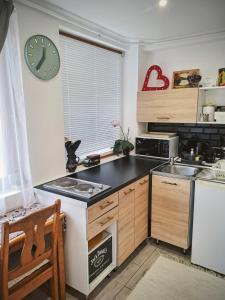 a kitchen with a counter and a clock on the wall at No°21 Apartman in Szilvásvárad