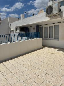 a house with a white fence and a patio at Cosy Apparemment in Nabeul