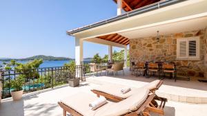 a patio with a table and chairs on a balcony at Villa Julija by Villas Guide in Smokvica