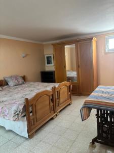 a bedroom with a wooden bed and a table at Cosy Apparemment in Nabeul +2 photos