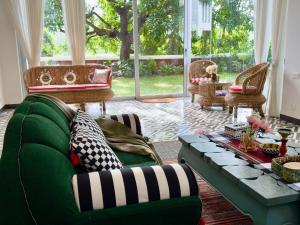 a living room with a green couch and a table at Big Pvt Pool & Garden 3BHK Villa, Morjim Beach 10-14mts in Siolim