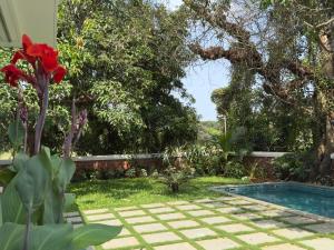 a garden with a swimming pool and trees at Big Pvt Pool & Garden 3BHK Villa, Morjim Beach 10-14mts in Siolim