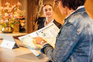 two women standing at a table with a laptop at Carlton Oasis Hotel in Spijkenisse