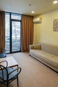 a living room with a couch and a table and a window at LALO Hotel Abastumani in Abastumani +129 photos