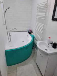 a bathroom with a bath tub and a sink at No°21 Apartman in Szilvásvárad +24 photos