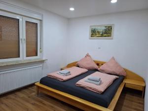 a bedroom with a bed with pink pillows on it at Ferienhaus Werratalsee in Frieda