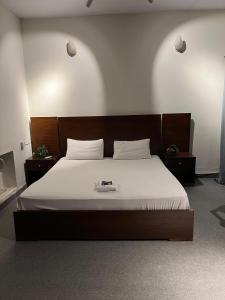 a bedroom with a large bed with a wooden headboard at Durrani Executive - Islamabad F10 in Islamabad