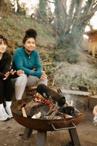 a group of people sitting around a fire at Kestrel lodge in Wrexham
