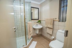 a bathroom with a shower and a toilet and a sink at Carousel Eco Estate in Temba +28 photos