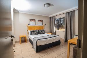 a hotel room with a bed and a window at Carousel Eco Estate in Temba