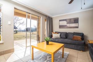 a living room with a couch and a table at Carousel Eco Estate in Temba