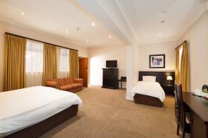 a hotel room with two beds and a chair at Cumberland Hotel & Conference Centre Worcester in Worcester +42 photos