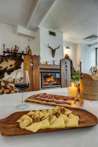a table with a plate of cheese and a glass of wine at Ema Hotel Bansko in Bansko