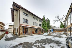 a building with snow on the ground in front of it at Ema Hotel Bansko in Bansko