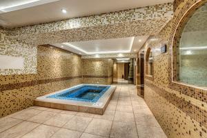 a bathroom with a hot tub in a room with tiles at Ema Hotel Bansko in Bansko