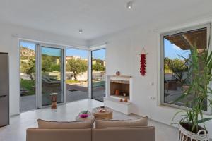 a living room with a couch and a fireplace at Annassa Experience Villa 2' walk from Almyrida beach in Almyrida