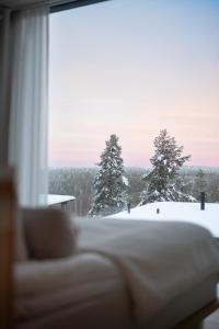 a window with a view of snow covered trees at Arctic TreeHouse Hotel in Rovaniemi