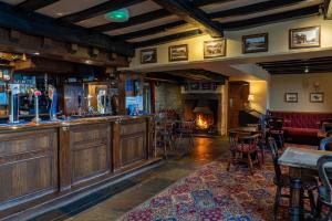 a bar in a pub with a fireplace in the background at The Dog and Partridge in Langsett