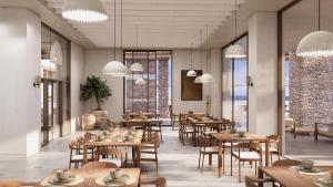 a restaurant with wooden tables and chairs and windows at Tinos Beach Hotel in Kionia