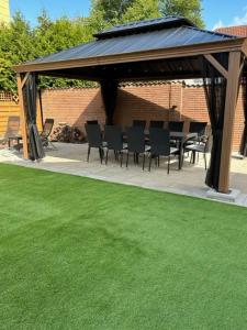 a gazebo with chairs and a table and a green lawn at Rodenbach 1 BR Apartment in Rodenbach +4 photos
