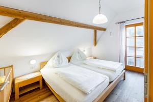 two beds in a room with a window at Buchgrabenhof in Windisch Minihof