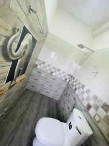 a bathroom with a toilet and a picture of an elephant at Woori House in Kamburugamuwa