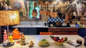 a kitchen with a table with a bowl of fruit on it at La Demeure du Figuier in Évran