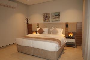 a bedroom with a large bed with white sheets and pillows at Albateel 2 Serviced Apartments-اقتصادي in Riyadh +13 photos